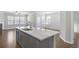 Kitchen island features a sink with faucet, gray cabinets, and granite countertop with living area in the background at 404 Village Ln, Fairburn, GA 30213