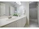 Well-lit bathroom featuring double sinks, a large mirror, and tiled shower at 5355 Avonshire Ln, Cumming, GA 30040