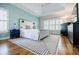 Serene main bedroom with a tray ceiling, white bedding, blue accent wall, and plantation shutters at 5355 Avonshire Ln, Cumming, GA 30040