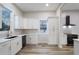 Well-lit kitchen boasts white cabinetry, modern appliances, gold hardware, and wood-look flooring at 190 Adair Se Ave, Atlanta, GA 30315