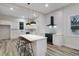 Modern kitchen with white cabinets, stainless steel appliances, large island with pendant lights, and wood-look floors at 190 Adair Se Ave, Atlanta, GA 30315