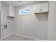 Modern laundry room featuring window, cabinets for storage, neutral paint, and tile floors at 190 Adair Se Ave, Atlanta, GA 30315