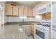 Cozy kitchen with granite countertops, white appliances, and light-colored wood cabinets at 215 Piedmont Ne Ave # 204, Atlanta, GA 30308