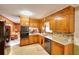 This is a cozy kitchen with wood cabinets, tile backsplash, and modern appliances at 2798 Tralyn Ct, Decatur, GA 30034