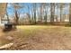 The grassy backyard is surrounded by bare trees and a wooden fence that create a natural boundary at 2825 Middleburg Dr, Atlanta, GA 30349