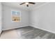 Bright bedroom with wood-style floors, a ceiling fan and natural light from the single window at 2825 Middleburg Dr, Atlanta, GA 30349