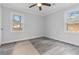 Bedroom with newly installed gray-toned flooring, two windows, and a ceiling fan at 2825 Middleburg Dr, Atlanta, GA 30349