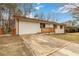 View of the house with a driveway, white exterior, brown trim, and a small porch at 2825 Middleburg Dr, Atlanta, GA 30349