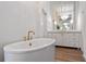 Bright bathroom featuring a white vanity and a soaking tub with gold hardware at 170 Boulevard Se # 412E, Atlanta, GA 30312