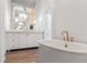 Bright bathroom featuring a white vanity and a soaking tub with gold hardware at 170 Boulevard Se # 412E, Atlanta, GA 30312