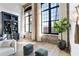 Airy living room boasting exposed brick, oversized windows, custom shelving, and hardwood floors at 170 Boulevard Se # 412E, Atlanta, GA 30312