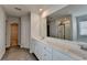 Bright bathroom featuring a double sink vanity, large mirror, shower, and modern gray flooring at 1883 Frisco Way, Suwanee, GA 30024