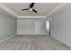 Spacious bedroom with neutral tones, a ceiling fan, and carpet floors at 1883 Frisco Way, Suwanee, GA 30024