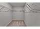 Walk-in closet with carpet and white-painted metal shelving and rods at 1883 Frisco Way, Suwanee, GA 30024