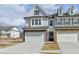 Charming two-story townhome with an attached two-car garage, brick accents, and gray siding at 1883 Frisco Way, Suwanee, GA 30024