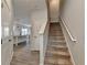 Hallway view featuring wood-look floors, a staircase, and a glimpse into the kitchen with a large island at 1883 Frisco Way, Suwanee, GA 30024