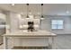 Open concept kitchen featuring an island with granite countertops, stainless appliances, and stylish pendant lighting at 1883 Frisco Way, Suwanee, GA 30024