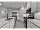 Close up view of modern kitchen with granite counters, stainless appliances, and wood-look floors at 1883 Frisco Way, Suwanee, GA 30024