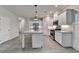 Bright kitchen with stainless steel appliances, island with granite countertops, and wood-look flooring at 1883 Frisco Way, Suwanee, GA 30024