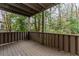 A cozy covered back porch with painted wood railing overlooks a wooded scene at 20 Ivy Ne Rdg, Atlanta, GA 30342