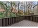 A cozy covered back porch with painted wood railing overlooks a wooded scene at 20 Ivy Ne Rdg, Atlanta, GA 30342