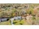 Aerial view showcasing the stunning home, landscape, and a serene lake surrounded by vibrant fall foliage at 205 Pine Knott Rd, Fayetteville, GA 30214