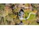 Aerial view of house with lush backyard, curved driveway, and surrounding mature trees, exuding privacy and elegance at 205 Pine Knott Rd, Fayetteville, GA 30214