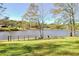 Backyard featuring mature trees, waterfront access, and lush green lawn at 205 Pine Knott Rd, Fayetteville, GA 30214