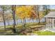 Scenic backyard with mature trees, a lake view, a vintage swing set, and a glimpse of a screened-in porch at 205 Pine Knott Rd, Fayetteville, GA 30214