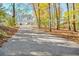 Long paved driveway leading to a charming home nestled among colorful trees at 205 Pine Knott Rd, Fayetteville, GA 30214