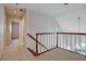 Upstairs hallway featuring neutral carpet, wood railings and access to a bathroom at 205 Pine Knott Rd, Fayetteville, GA 30214