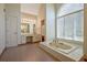 Bright and airy main bathroom with a tub under arched window and vanity area at 205 Pine Knott Rd, Fayetteville, GA 30214