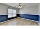 This bedroom features wood floors, a ceiling fan, and a large window with blinds at 4032 Copper Creek Way, Buford, GA 30519