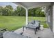 Relaxing covered patio with comfortable seating area overlooking a sprawling green lawn at 1193 Burlington Ct, Mcdonough, GA 30253