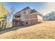 View of the back of the house from the yard showcasing a deck, brick facade, and siding at 1526 Rocky River Dr, Lawrenceville, GA 30045