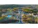 Aerial view of a community pool, clubhouse, and playground nestled among trees and new homes at 1808 Lacebark Elm Way, Lawrenceville, GA 30045