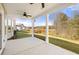 Covered outdoor patio with a ceiling fan overlooks a landscaped backyard with a view of the woods at 1808 Lacebark Elm Way, Lawrenceville, GA 30045