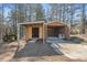 An outbuilding with a shed and garage and a John Deere tractor near a wooded area on a sunny day at 202 Neely Rd, Fayetteville, GA 30214