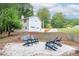 Backyard features a white home with a garage, outdoor seating area with four dark-colored Adirondack chairs at 185 Bob White Dr, Stockbridge, GA 30281