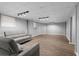 Finished basement with gray couches, wood-look flooring, recessed lights, and neutral wall color at 185 Bob White Dr, Stockbridge, GA 30281
