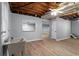 Spacious basement with a utility sink, window, wood-look flooring, and access to additional spaces at 185 Bob White Dr, Stockbridge, GA 30281
