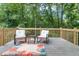 Outdoor deck with chairs and table featuring a scenic view of the lush, green backyard at 185 Bob White Dr, Stockbridge, GA 30281