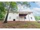 Back exterior of a white two-story home with a deck, trees, and a sloped yard at 185 Bob White Dr, Stockbridge, GA 30281