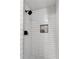 Modern shower stall featuring white subway tile, dark fixtures, and a built-in niche at 185 Bob White Dr, Stockbridge, GA 30281
