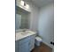 Clean half bathroom with a modern white vanity, toilet, and a contrasting dark door handle at 1932 Appian Aly, Kennesaw, GA 30144