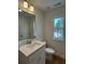 Bathroom with hardwood floors, single sink vanity, and a window with a backyard view at 1932 Appian Aly, Kennesaw, GA 30144