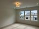 This bedroom has neutral carpeting, a modern ceiling light and a large window for natural lighting at 1932 Appian Aly, Kennesaw, GA 30144