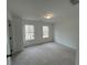 Clean, carpeted bedroom with two windows offering natural light and neutral decor at 1932 Appian Aly, Kennesaw, GA 30144