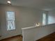 A hallway with hardwood floors and white railing featuring two windows that provide lots of light at 1932 Appian Aly, Kennesaw, GA 30144