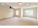 Bonus room with neutral carpet, ceiling fan, and lots of natural light from windows at 3455 Dalwood Dr, Suwanee, GA 30024